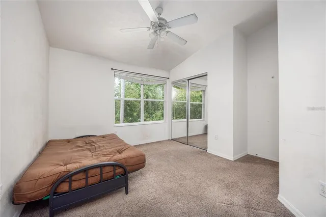 a spacious bedroom with a bed and a chandelier