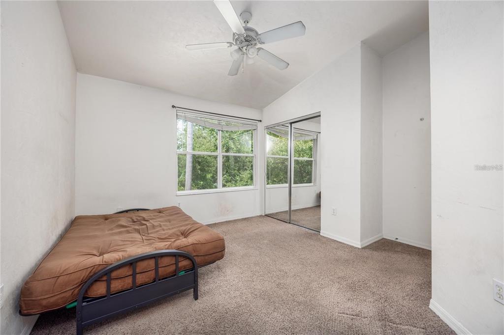 3970 Southwest 20th Avenue, Unit 909 Gainesville, FL 32607 - Photo 15 of 22 a spacious bedroom with a bed and a chandelier