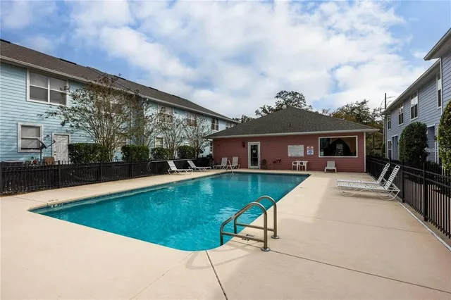 a view of house with swimming pool and furniture