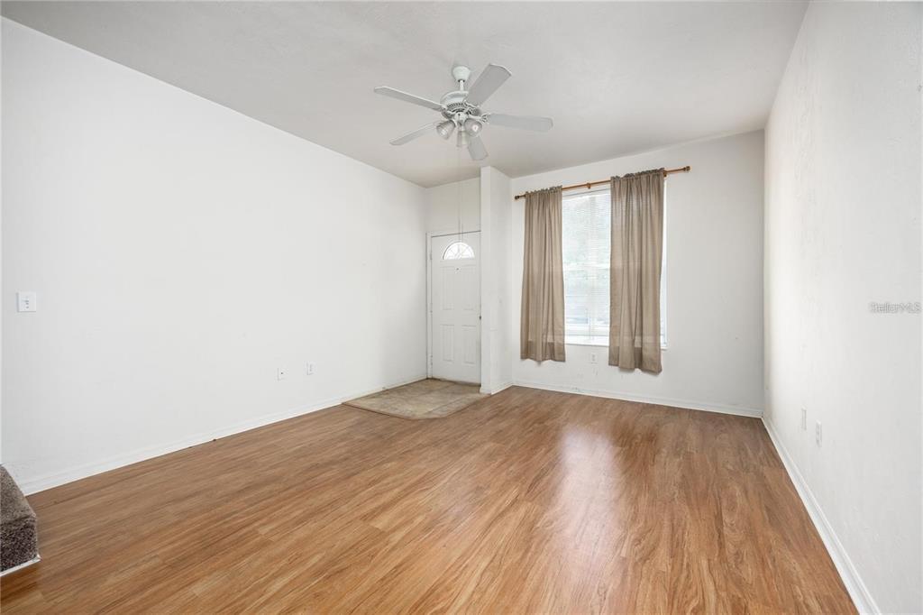 3970 Southwest 20th Avenue, Unit 909 Gainesville, FL 32607 - Photo 5 of 22 a view of an empty room with a window and wooden floor