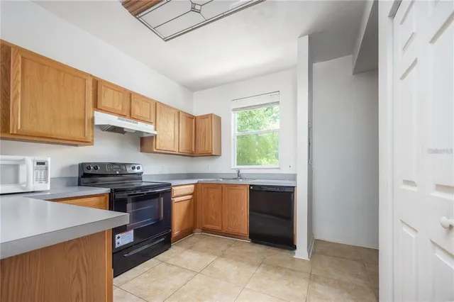 a kitchen with stainless steel appliances granite countertop a stove a sink dishwasher and a refrigerator