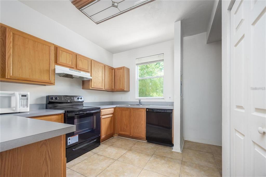3970 Southwest 20th Avenue, Unit 909 Gainesville, FL 32607 - Photo 10 of 22 a kitchen with stainless steel appliances granite countertop a stove a sink dishwasher and a refrigerator