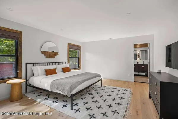 a large bed sitting in a bedroom with a painting on the wall