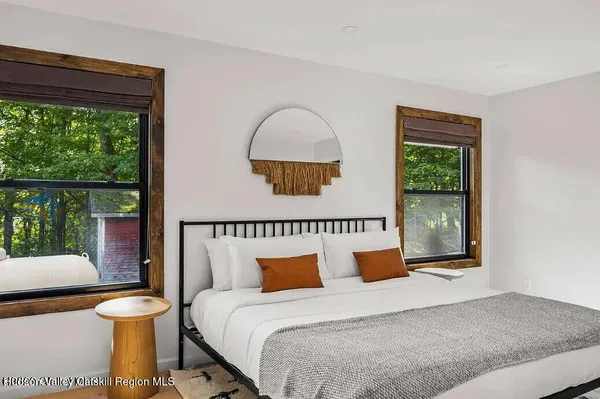 a view of a hallway with wooden floor and a living room
