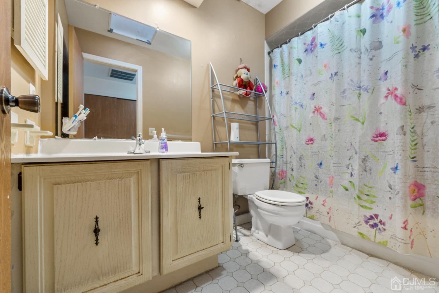 301 Maplecrest Road Edison, NJ 08820 - Photo 19 of 21 a bathroom with a sink toilet and shower curtain