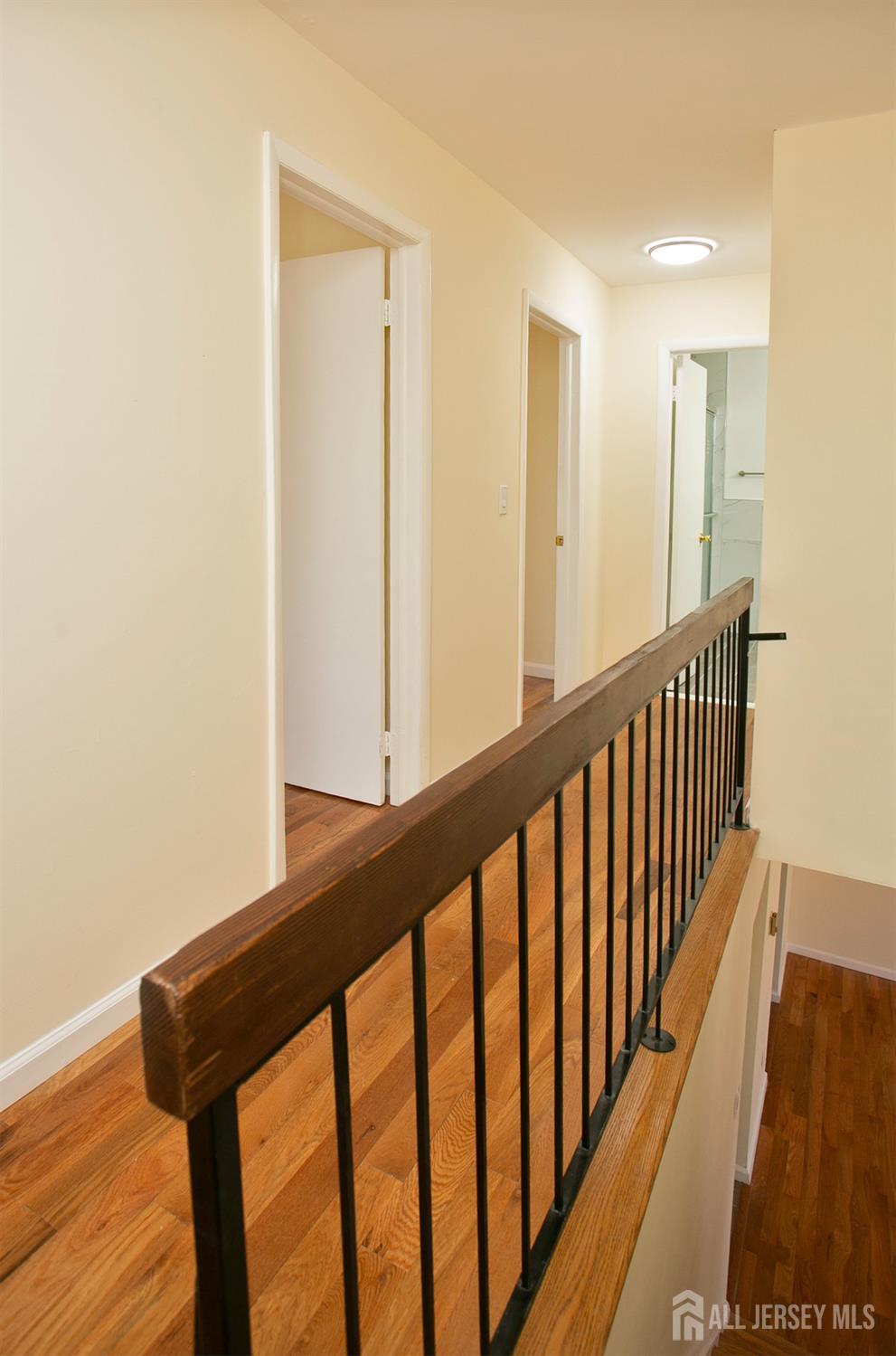 7 Cactus Court Edison, NJ 08820 - Photo 13 of 38 a view of a hallway with wooden floor and staircase