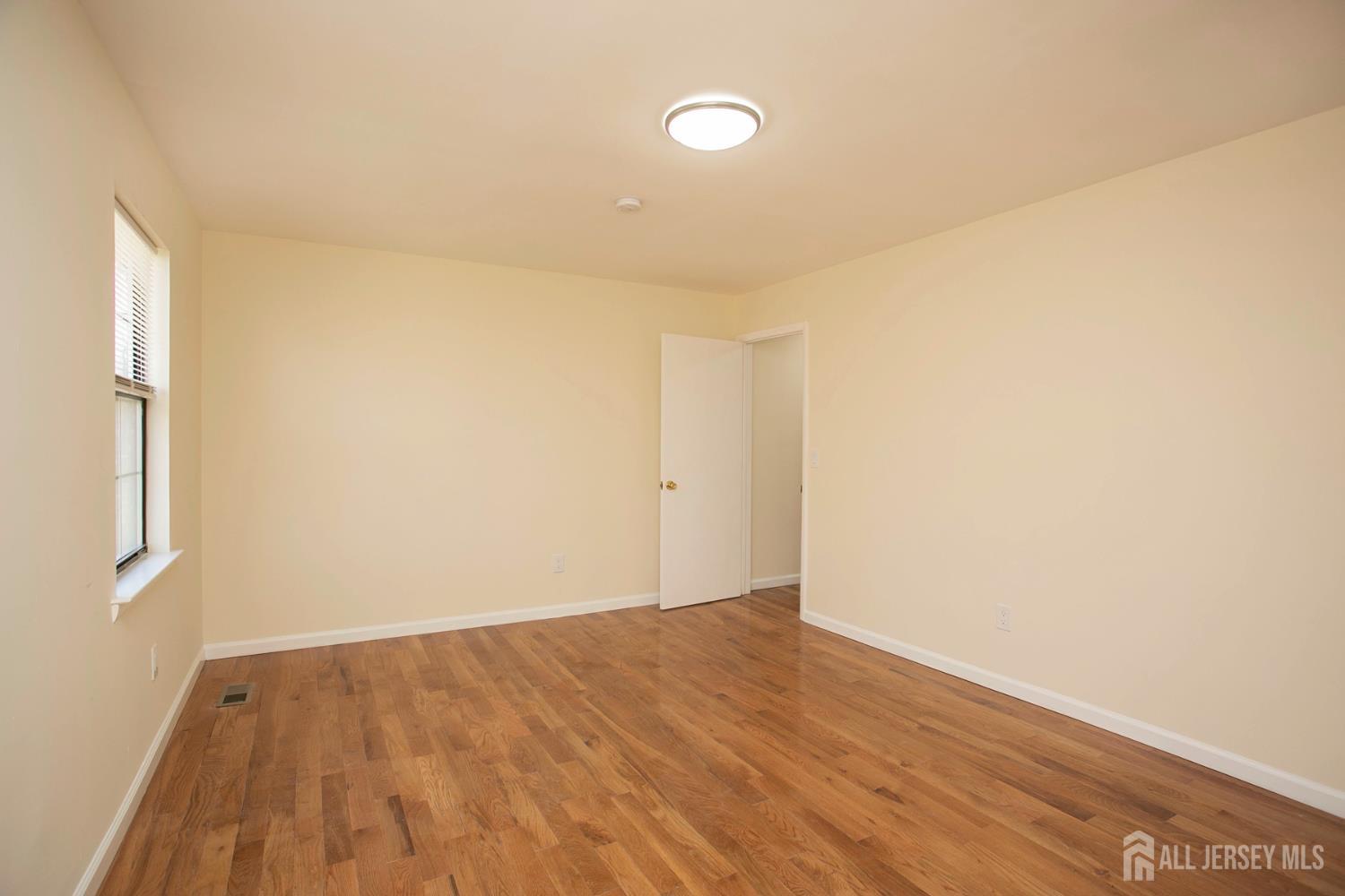 7 Cactus Court Edison, NJ 08820 - Photo 14 of 38 a view of an empty room with wooden floor