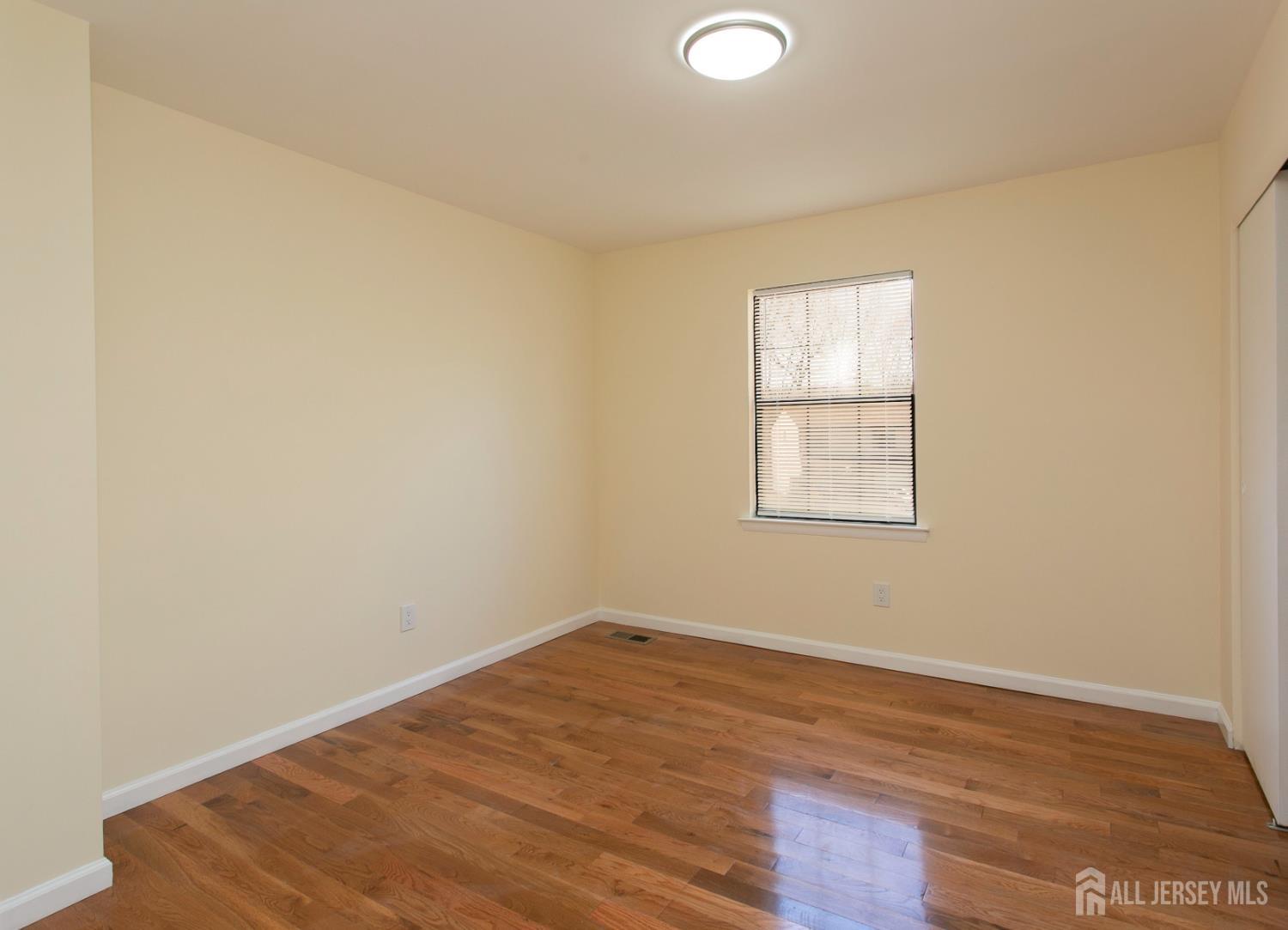 7 Cactus Court Edison, NJ 08820 - Photo 18 of 38 an empty room with wooden floor and windows