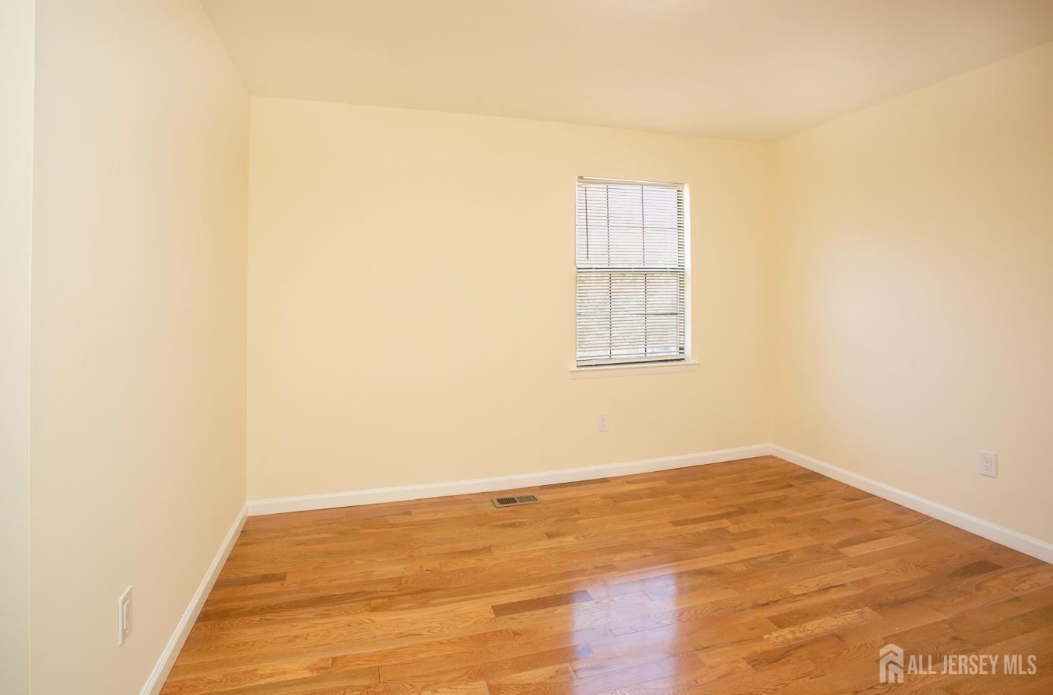 7 Cactus Court Edison, NJ 08820 - Photo 19 of 38 a view of an empty room with wooden floor and a window