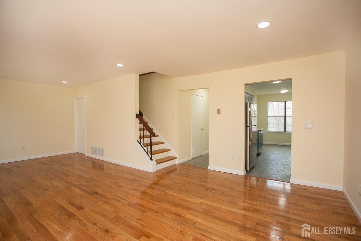 7 Cactus Court Edison, NJ 08820 - Photo 10 of 38 an empty room with wooden floor and stairs