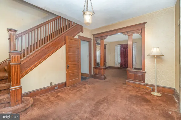 a view of a hallway with wooden floor and staircase