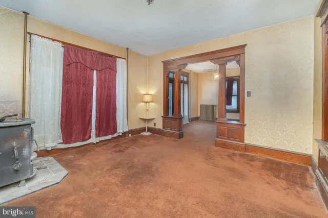 an empty room with mirror and a window