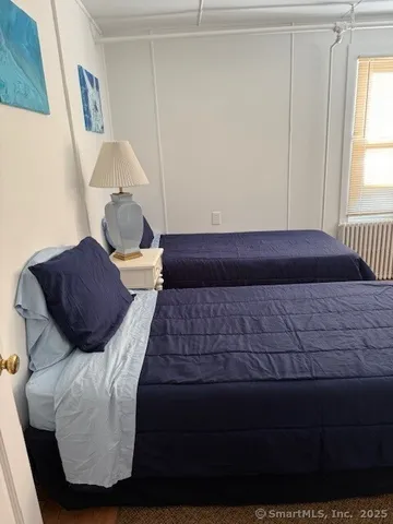 a bedroom with a bed lamp and a window