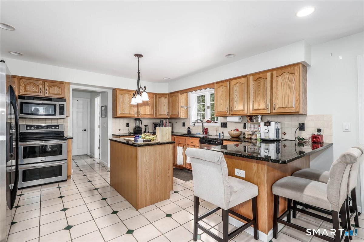 55 A Flax Hill Road Brookfield, CT 06804 - Photo 10 of 40 a kitchen with stainless steel appliances kitchen island granite countertop a refrigerator and a stove top oven