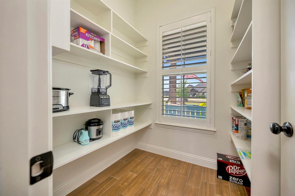 3224 North Cardinal Road Azle, TX 76020 - Photo 18 of 40 Spacious custom-built pantry featuring extensive shelving, wood-finish flooring, and a window with white plantation shutters