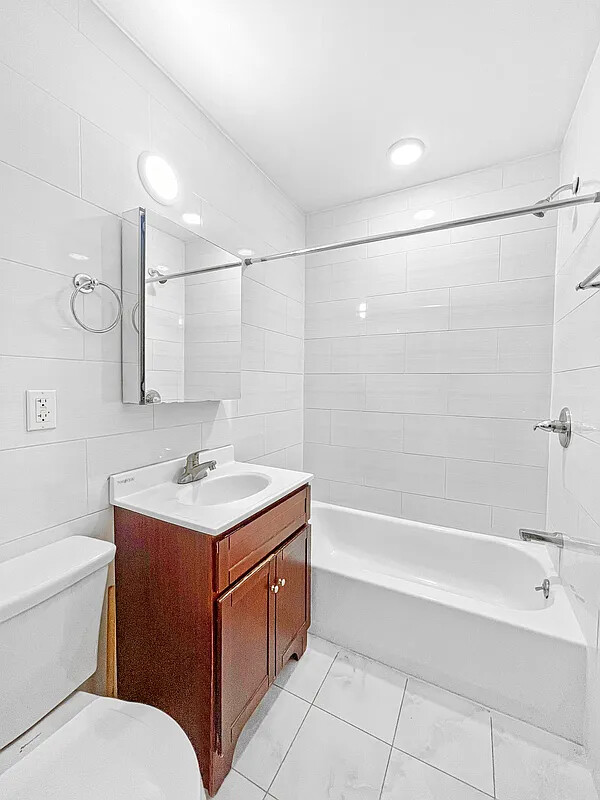 405 East 2nd Street, Unit 2 Brooklyn, NY 11218 - Photo 13 of 16 a bathroom with a sink toilet vanity and tub