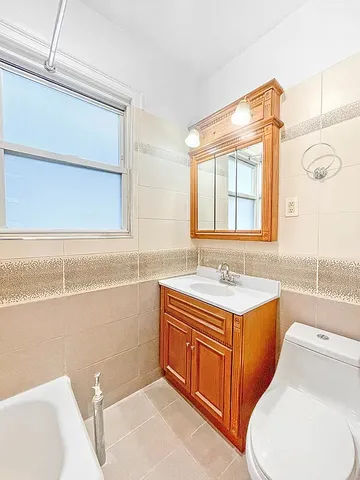 a bathroom with a sink toilet vanity and tub