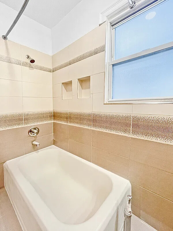 405 East 2nd Street, Unit 2 Brooklyn, NY 11218 - Photo 15 of 16 a bathroom with a tub and a shower