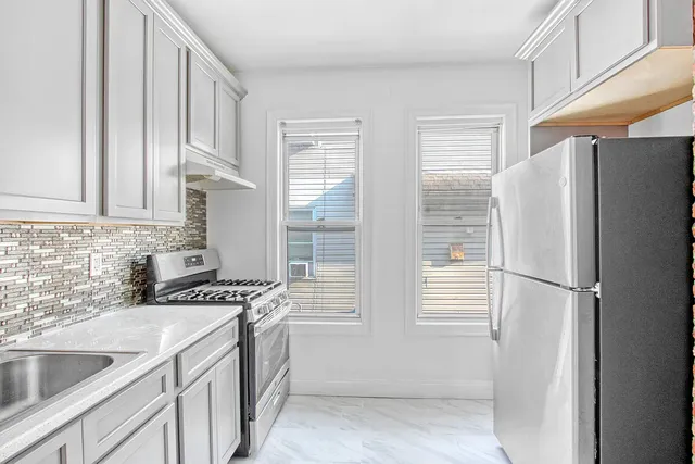 a kitchen with stainless steel appliances a refrigerator sink and cabinets