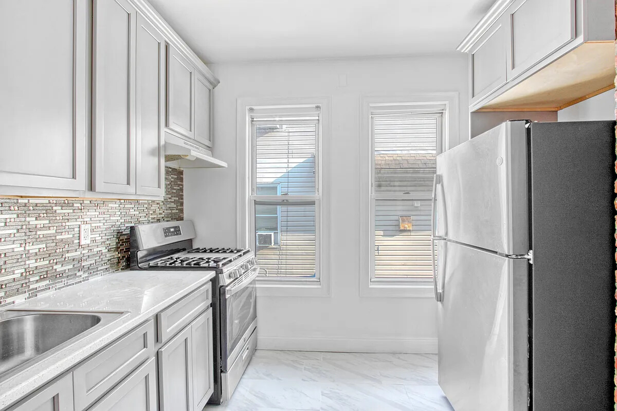 405 East 2nd Street, Unit 2 Brooklyn, NY 11218 - Photo 5 of 16 a kitchen with stainless steel appliances a refrigerator sink and cabinets
