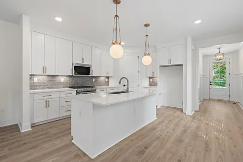 a kitchen with white cabinets and stainless steel appliances
