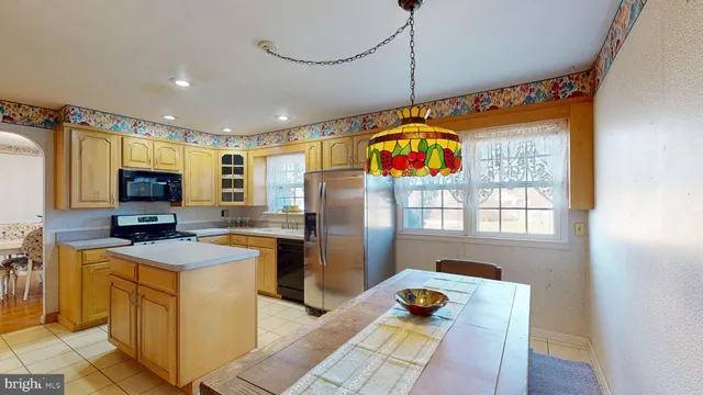 a kitchen that has a lot of cabinets a sink and a refrigerator