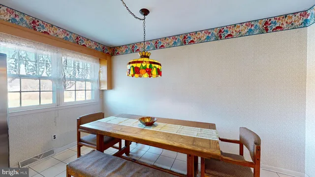a view of a dining room with furniture a chandelier and a window