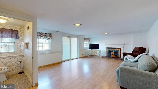 wooden floor fireplace and windows in an empty room