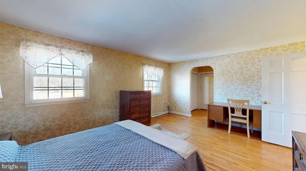 a bedroom with a bed and wooden floor