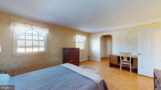 a bedroom with a bed and wooden floor