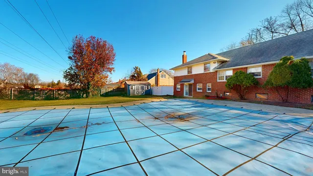 a view of swimming pool with outdoor seating and house in the background
