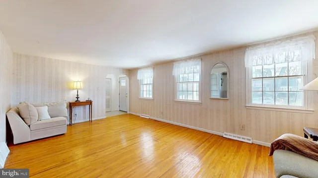 a spacious bedroom with a bed and wooden floor