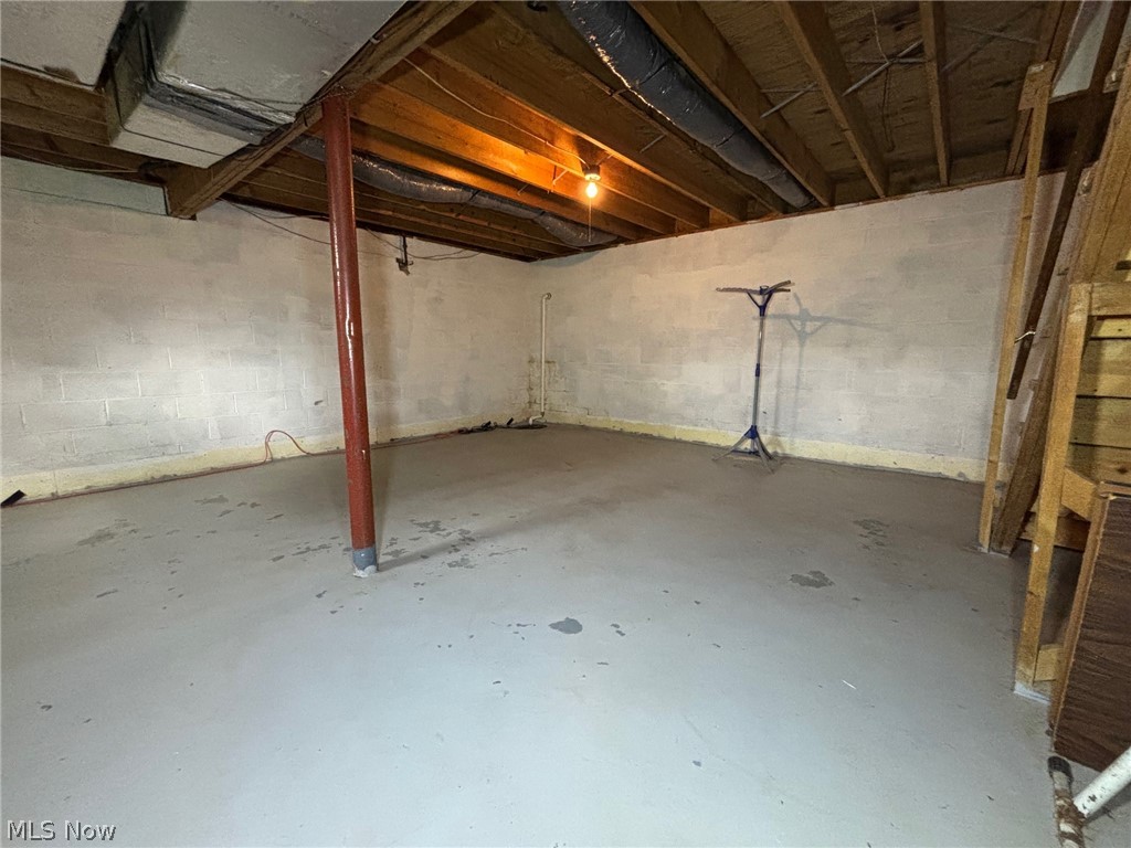 57575 Marietta Road Byesville, OH 43723 - Photo 20 of 25 Unfinished basement featuring block walls, concrete flooring, exposed wood joists, and an exposed support beam