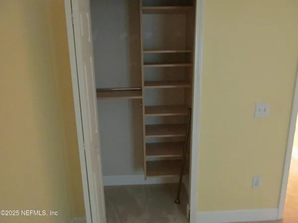 a view of walk in closet with empty racks