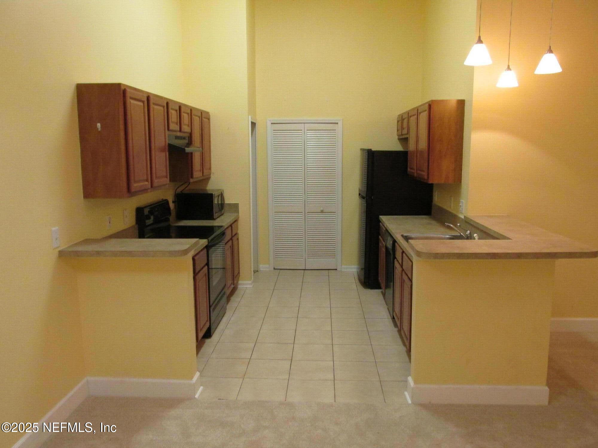 6057 Maggies Circle, Unit 114 Jacksonville, FL 32244 - Photo 7 of 28 a kitchen with a refrigerator and a stove