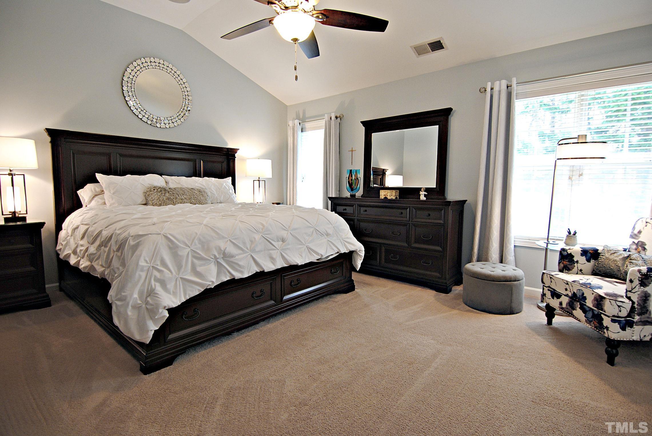 13222 Ashford Park Drive Raleigh, NC 27613 - Photo 16 of 30 a bedroom with a bed and a chandelier