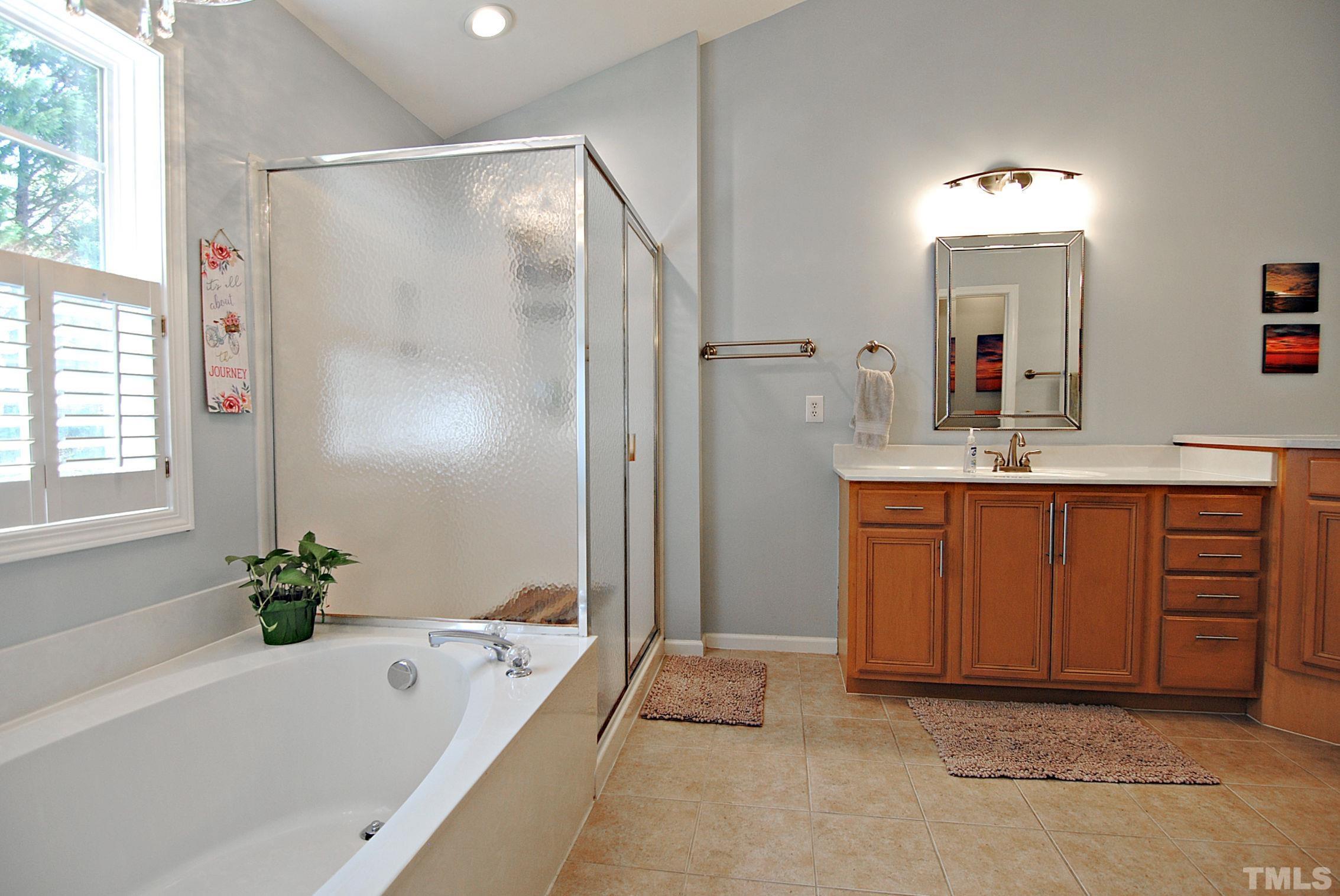 13222 Ashford Park Drive Raleigh, NC 27613 - Photo 17 of 30 a bathroom with a tub sink and mirror