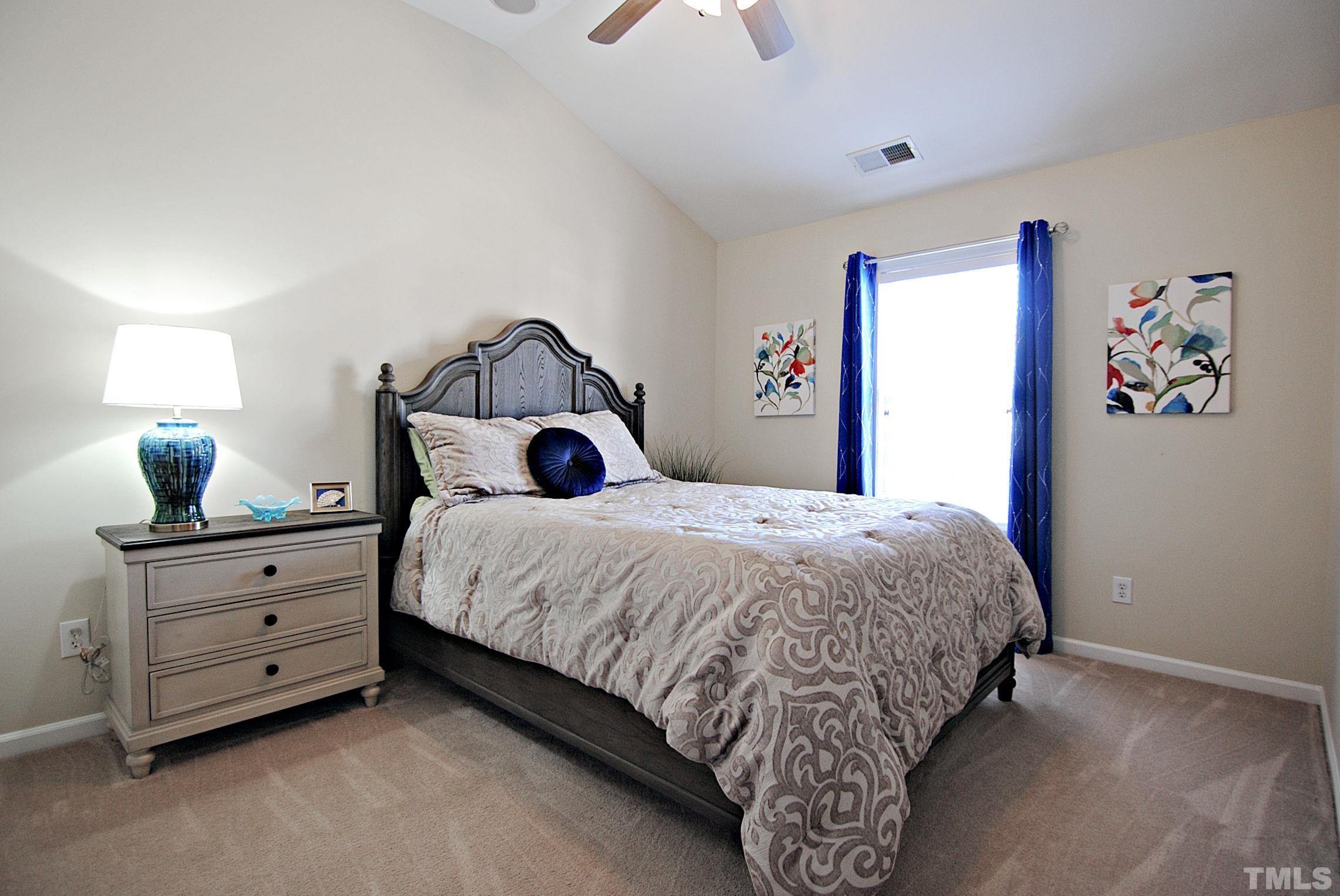 13222 Ashford Park Drive Raleigh, NC 27613 - Photo 19 of 30 a bedroom with a bed and a chandelier