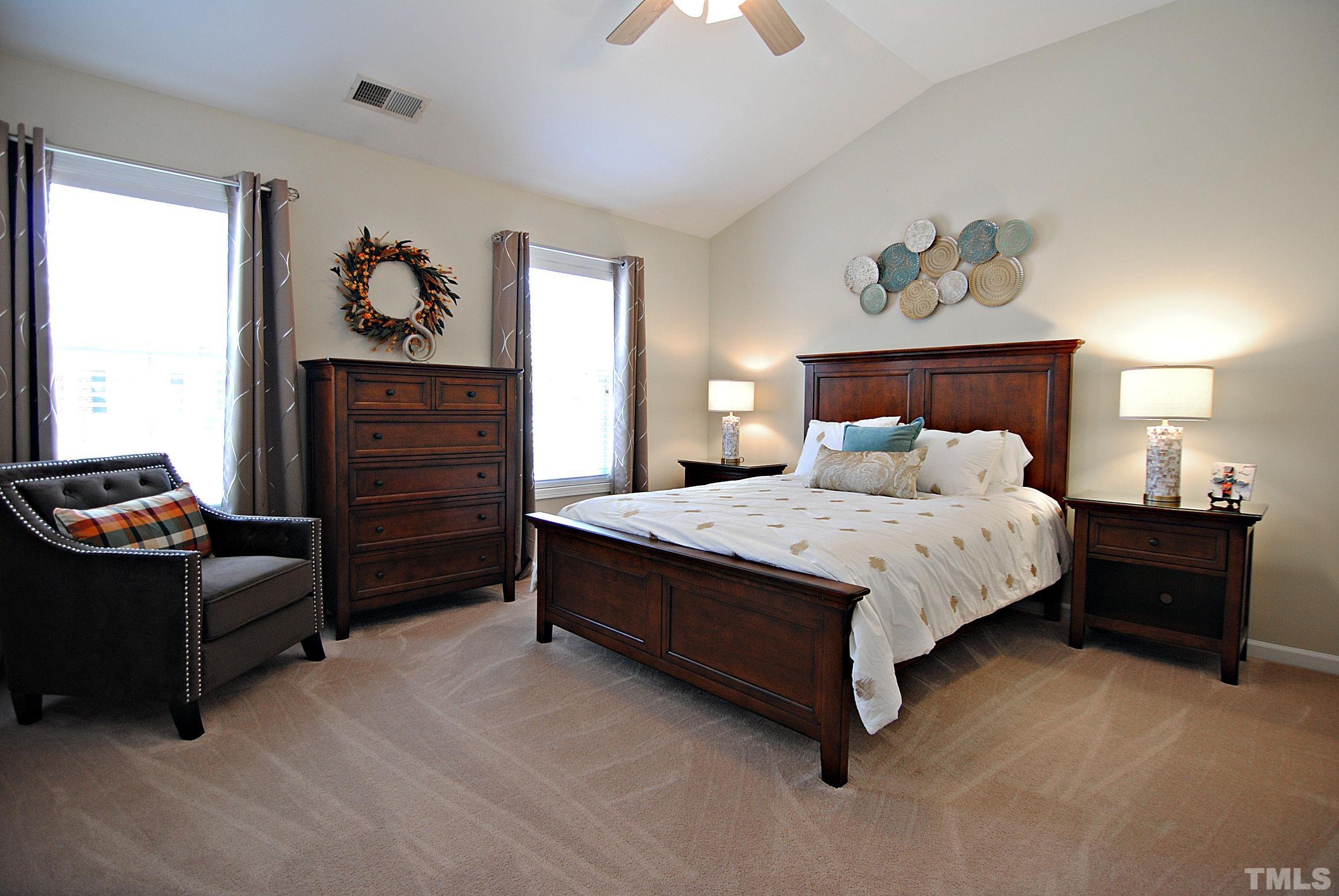 13222 Ashford Park Drive Raleigh, NC 27613 - Photo 20 of 30 a bedroom with a bed and a chandelier