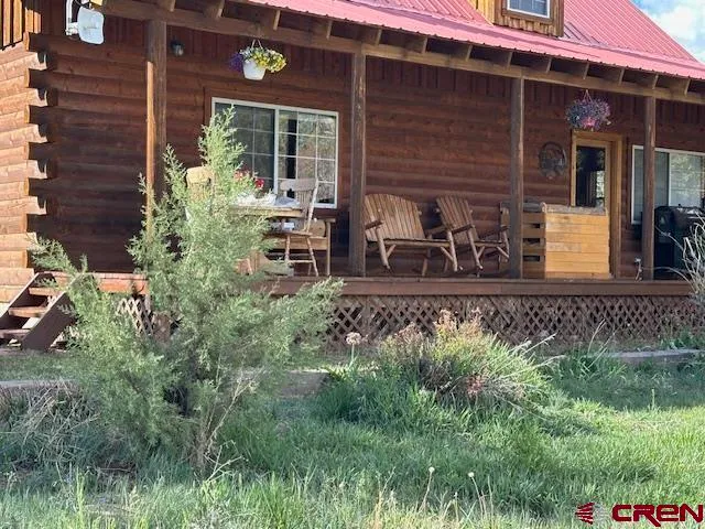 a view of a house with potted plants and a bench