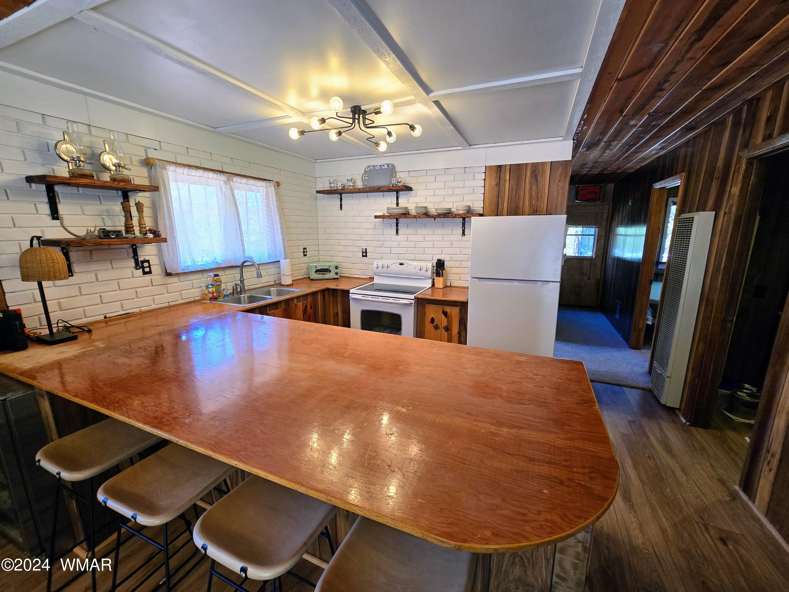 3058 Aspen Road Overgaard, AZ 85933 - Photo 8 of 15 a kitchen with a table chairs sink and cabinets