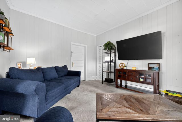 a living room with furniture a flat screen tv and a window