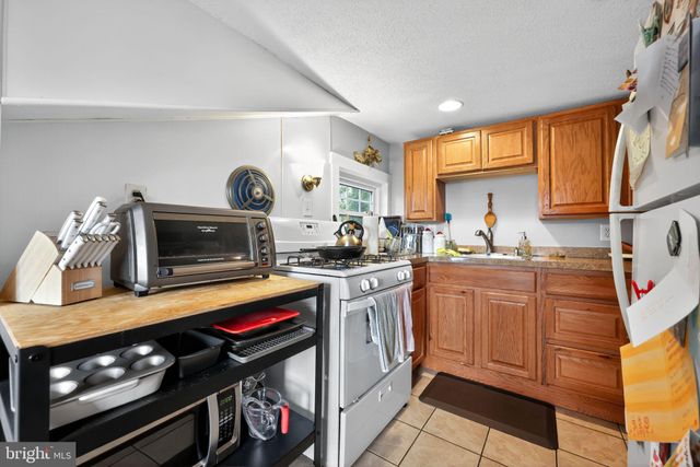 a kitchen with a refrigerator and a stove top oven