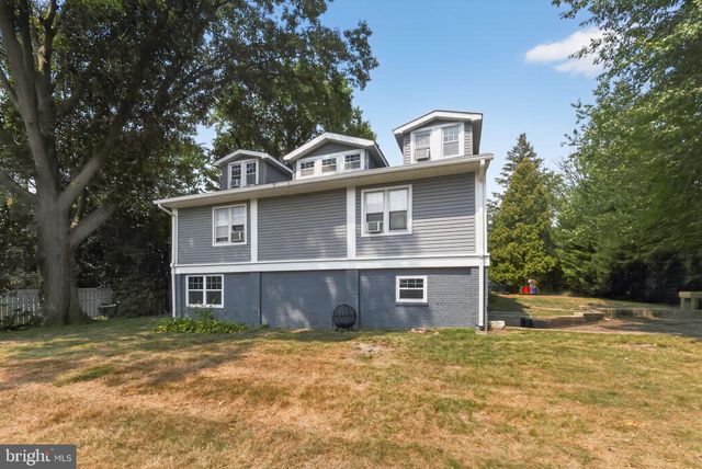 a front view of a house with a big yard and large trees