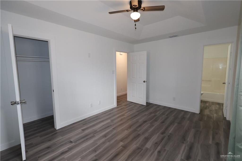 3526 Paseo Del Rey Edinburg, TX 78542 - Photo 12 of 20 Unfurnished bedroom featuring dark wood-style floors, a ceiling fan, and a raised ceiling