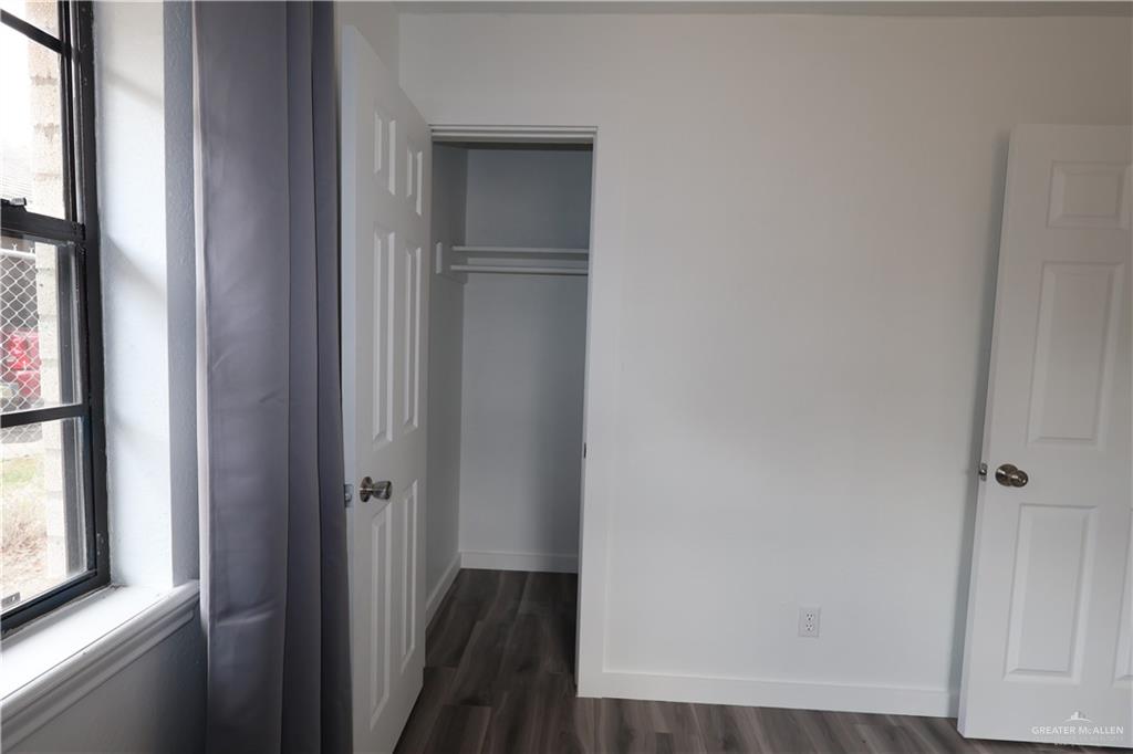3526 Paseo Del Rey Edinburg, TX 78542 - Photo 15 of 20 Unfurnished bedroom with multiple windows, dark wood-style flooring, and a closet