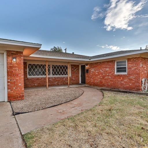 2110 65th Street Lubbock, TX 79412 - Photo 2 of 37 a front view of a house with garden