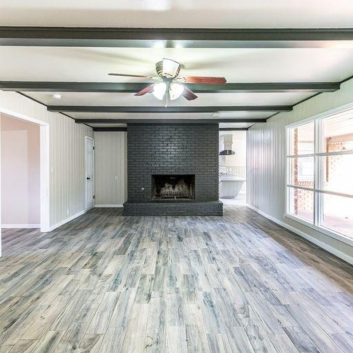 2110 65th Street Lubbock, TX 79412 - Photo 5 of 37 a view of empty room with wooden floor and fireplace
