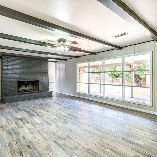 2110 65th Street Lubbock, TX 79412 - Photo 6 of 37 a view of an empty room with wooden floor and a window