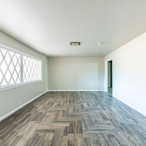 2110 65th Street Lubbock, TX 79412 - Photo 9 of 37 an empty room with wooden floor and windows